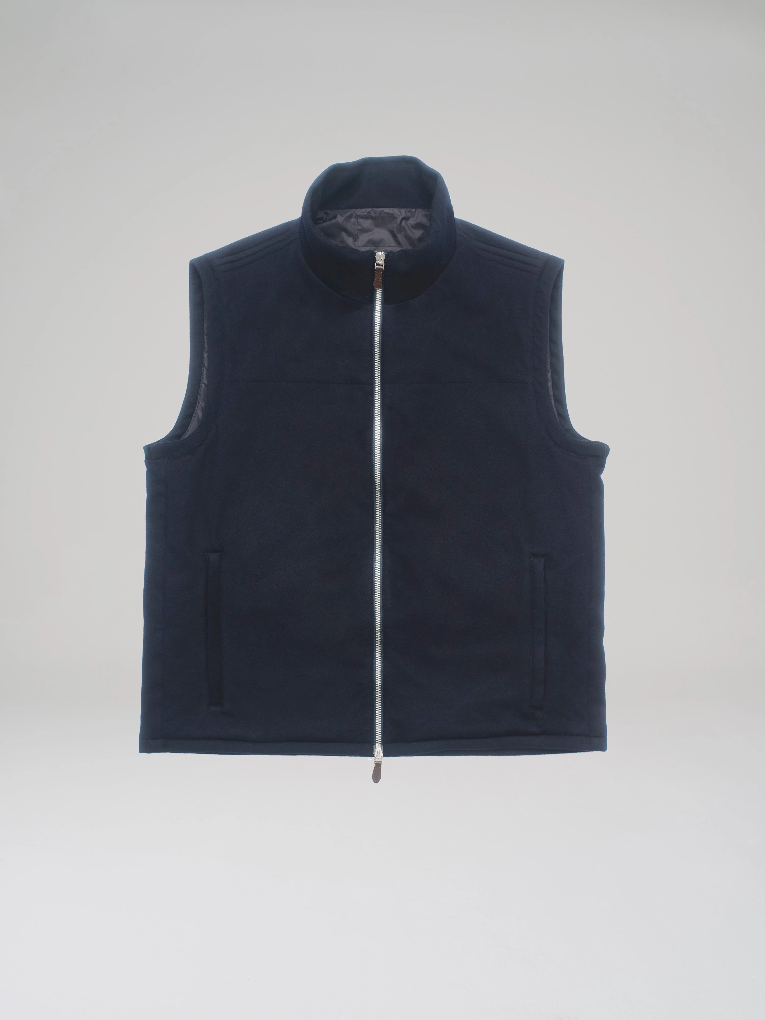 Front product shot of a dark blue cashmere bulletproof vest in a studio on a light grey background.