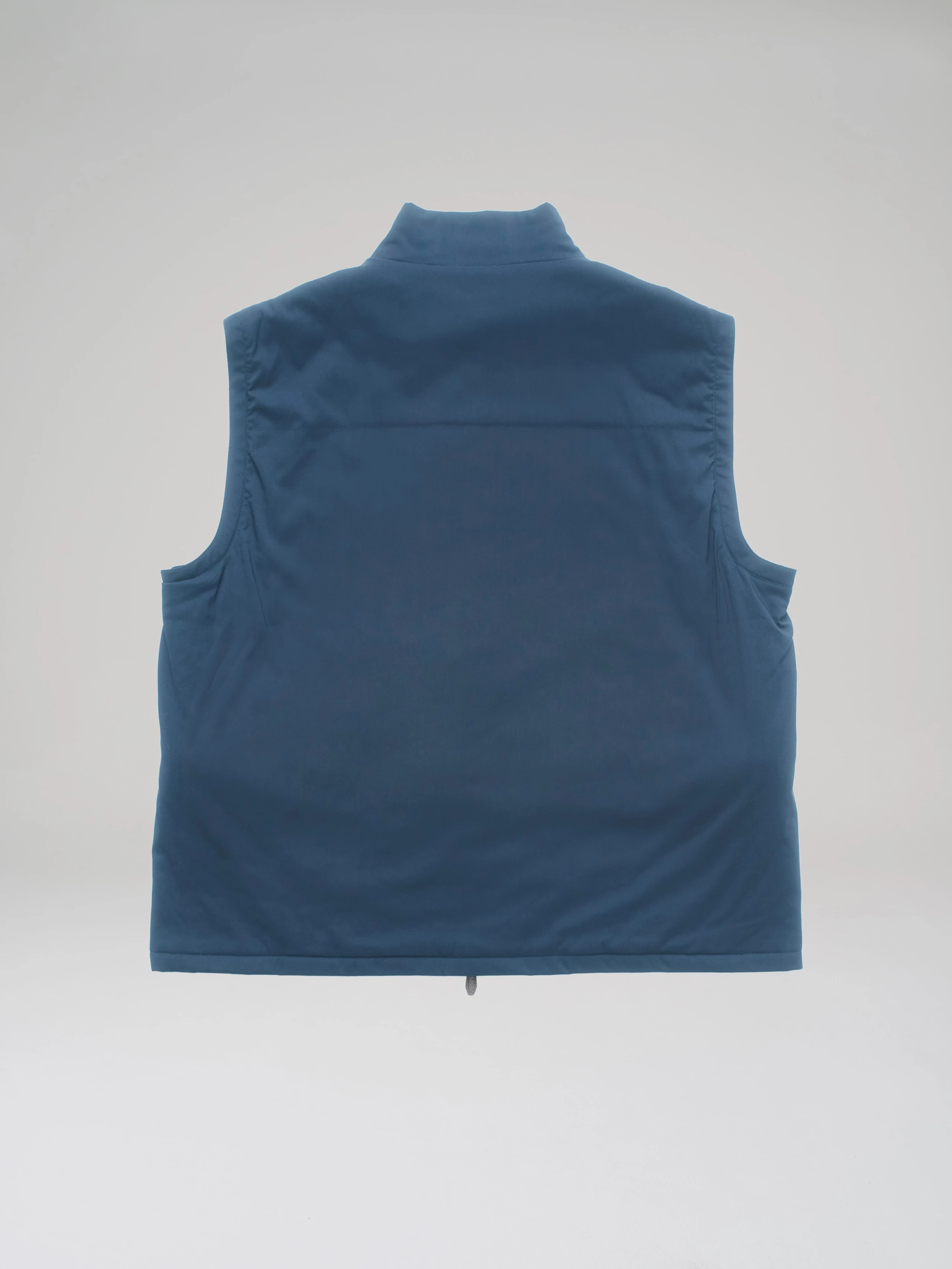 Product shot: back view of a blue bulletproof vest made from T-Way fabric in a studio on a light grey background.